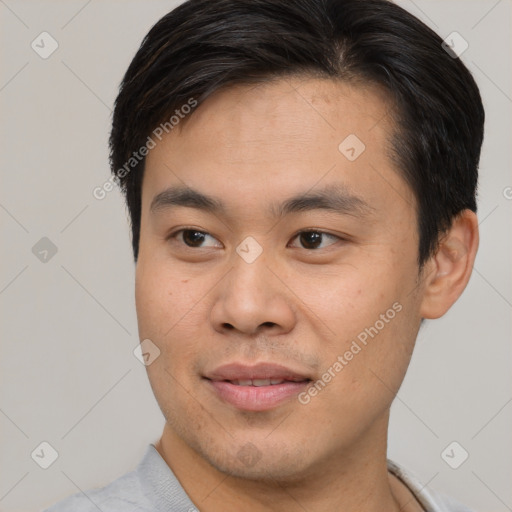 Joyful asian young-adult male with short  brown hair and brown eyes