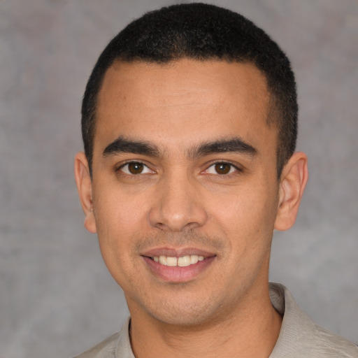 Joyful latino young-adult male with short  black hair and brown eyes