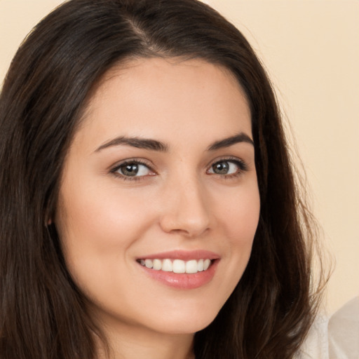 Joyful white young-adult female with long  brown hair and brown eyes