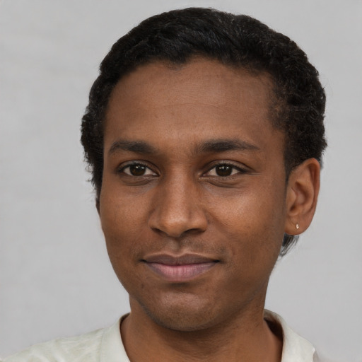 Joyful black young-adult male with short  black hair and brown eyes