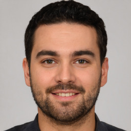 Joyful white young-adult male with short  black hair and brown eyes