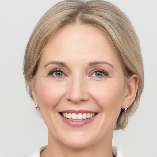 Joyful white adult female with medium  brown hair and grey eyes