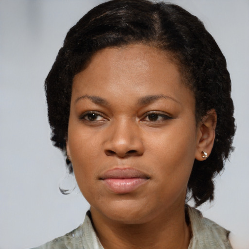Joyful black young-adult female with short  brown hair and brown eyes