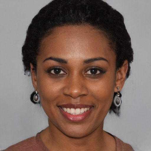 Joyful black young-adult female with short  black hair and brown eyes
