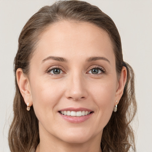 Joyful white young-adult female with long  brown hair and grey eyes