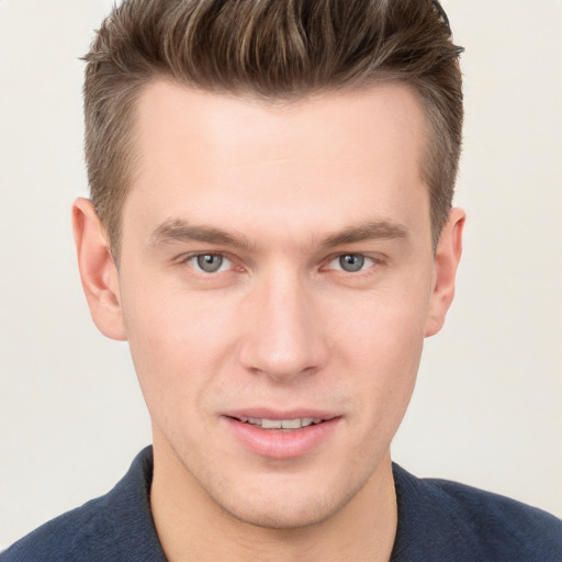 Joyful white young-adult male with short  brown hair and grey eyes