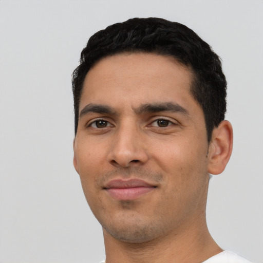 Joyful latino young-adult male with short  black hair and brown eyes