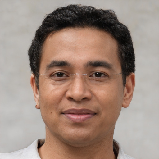 Joyful latino adult male with short  black hair and brown eyes