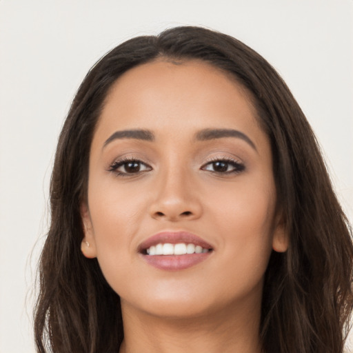 Joyful latino young-adult female with long  brown hair and brown eyes