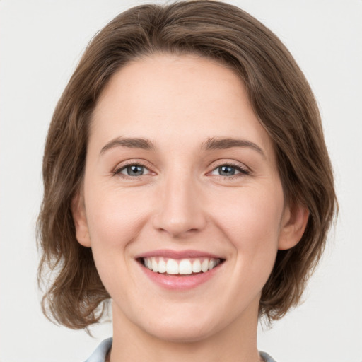 Joyful white young-adult female with medium  brown hair and green eyes