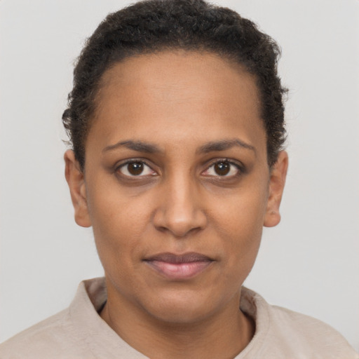 Joyful black young-adult female with short  brown hair and brown eyes