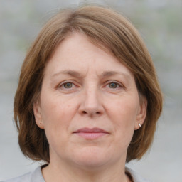 Joyful white adult female with medium  brown hair and blue eyes