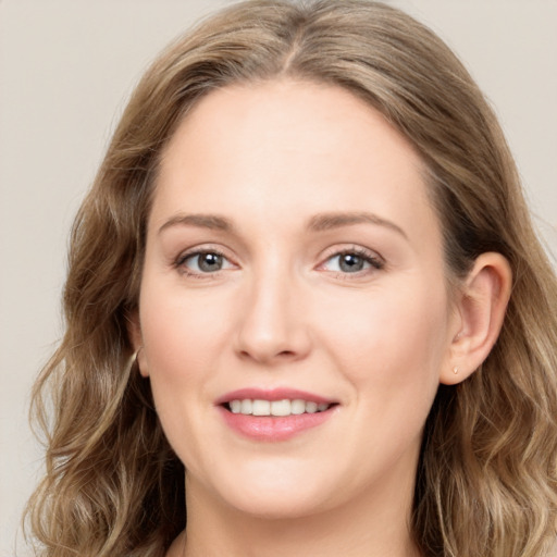 Joyful white young-adult female with long  brown hair and blue eyes