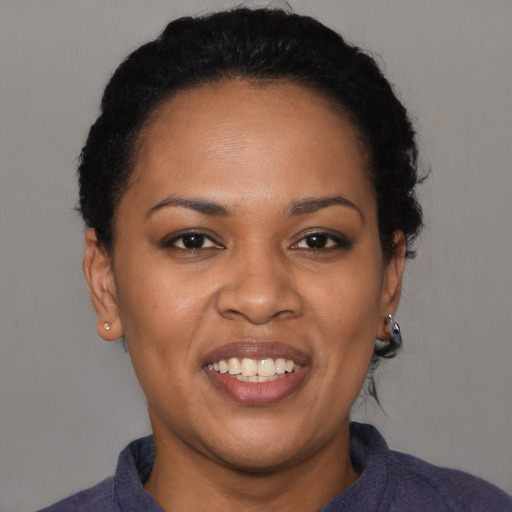 Joyful black young-adult female with short  black hair and brown eyes