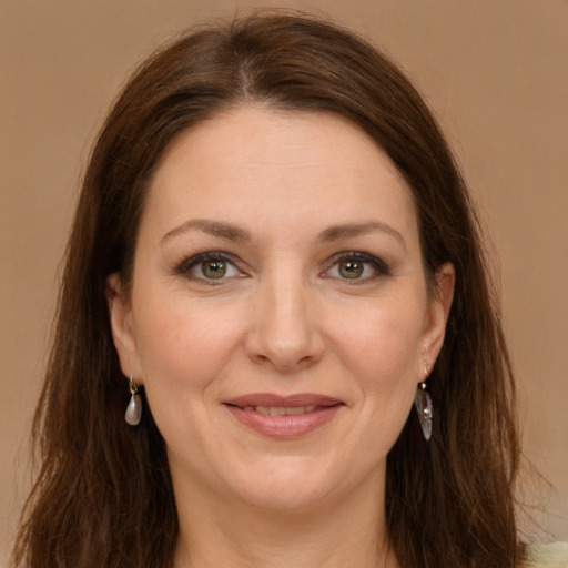 Joyful white adult female with long  brown hair and grey eyes