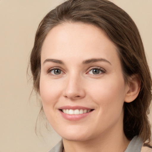 Joyful white young-adult female with medium  brown hair and grey eyes