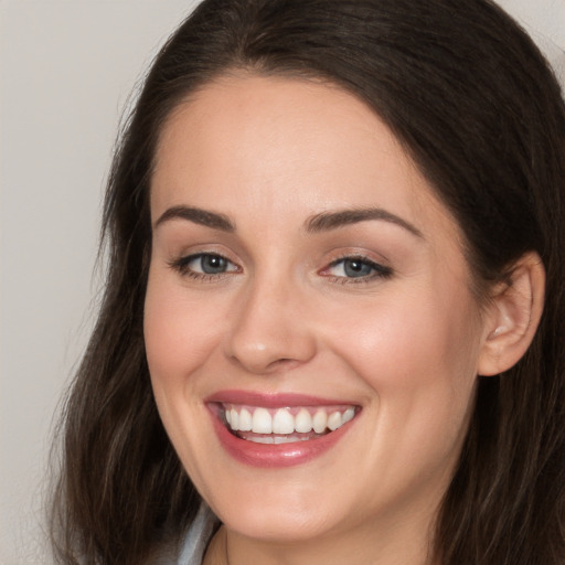 Joyful white young-adult female with long  brown hair and brown eyes