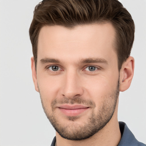 Joyful white young-adult male with short  brown hair and grey eyes