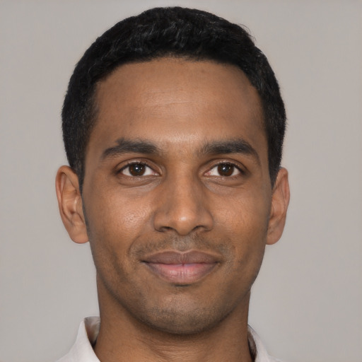 Joyful black young-adult male with short  black hair and brown eyes