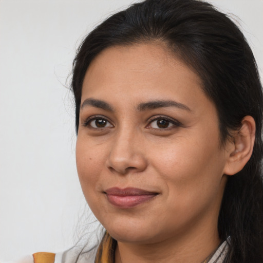 Joyful latino young-adult female with long  brown hair and brown eyes