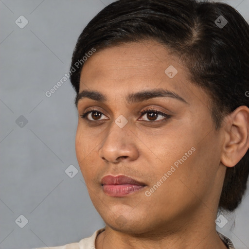 Joyful black young-adult female with short  black hair and brown eyes