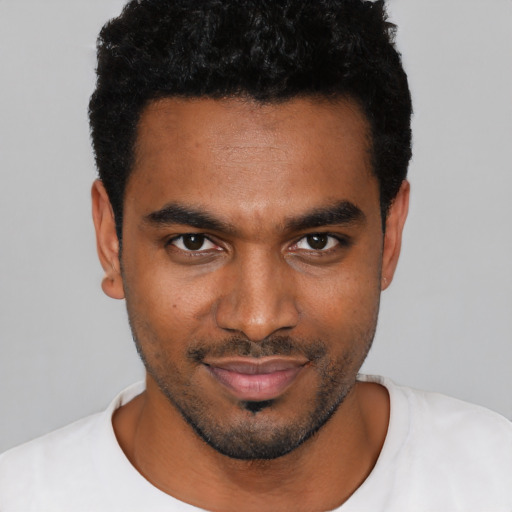 Joyful black young-adult male with short  black hair and brown eyes