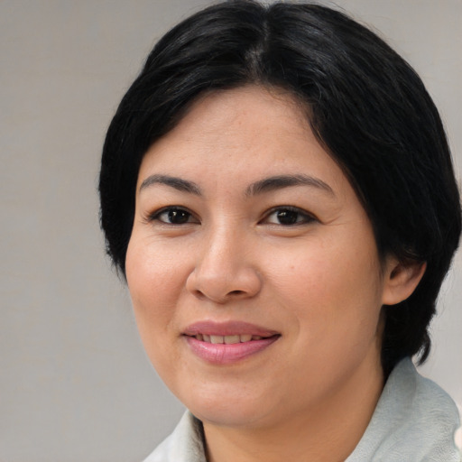 Joyful asian young-adult female with medium  black hair and brown eyes