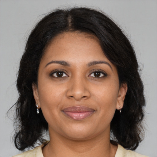 Joyful black young-adult female with medium  brown hair and brown eyes