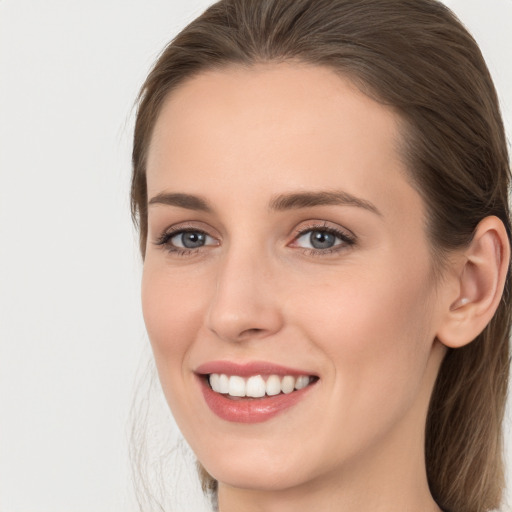 Joyful white young-adult female with long  brown hair and grey eyes