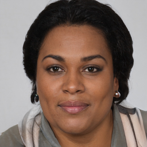 Joyful black adult female with medium  brown hair and brown eyes