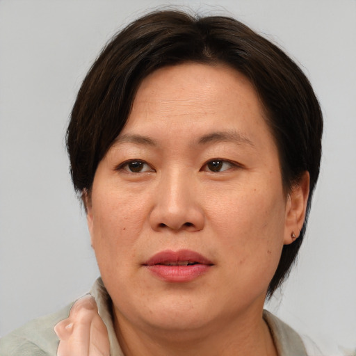 Joyful asian adult female with short  brown hair and brown eyes