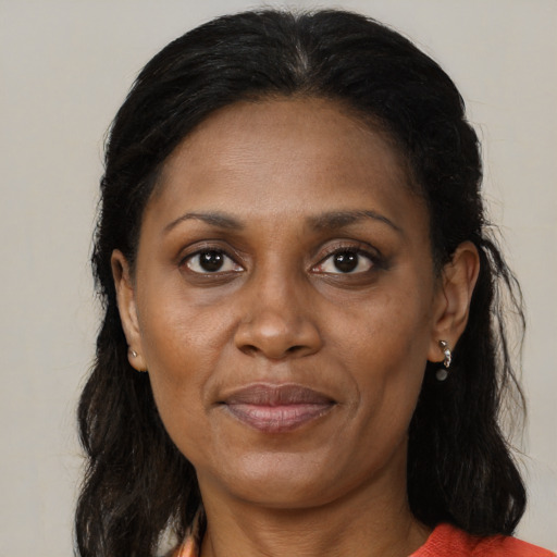 Joyful black adult female with long  brown hair and brown eyes