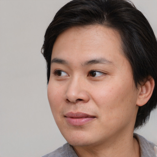 Joyful asian young-adult female with medium  brown hair and brown eyes