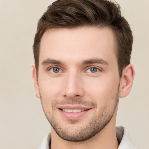 Joyful white young-adult male with short  brown hair and grey eyes