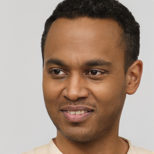 Joyful black young-adult male with short  brown hair and brown eyes