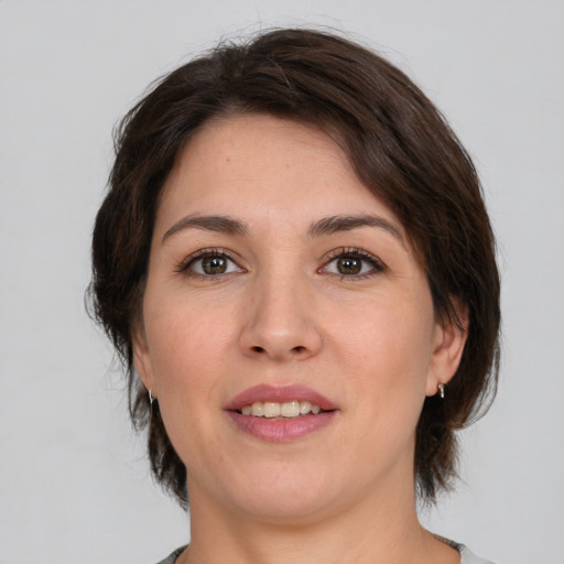 Joyful white young-adult female with medium  brown hair and green eyes