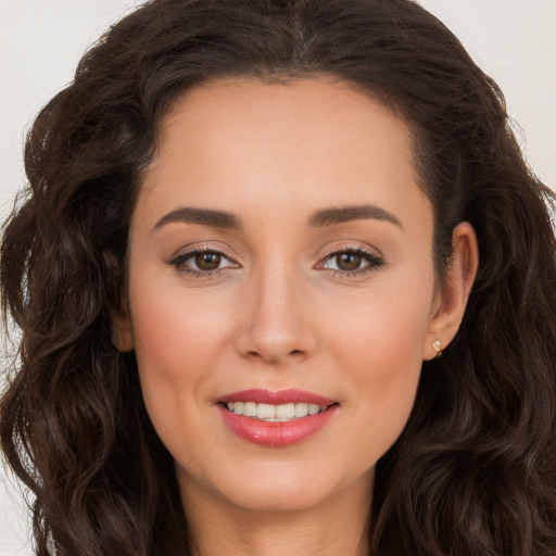 Joyful white young-adult female with long  brown hair and brown eyes