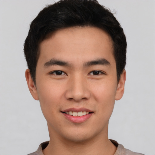 Joyful asian young-adult male with short  black hair and brown eyes