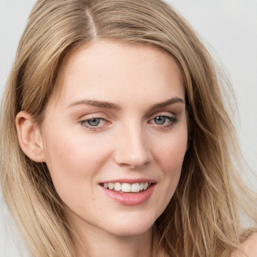 Joyful white young-adult female with long  brown hair and blue eyes