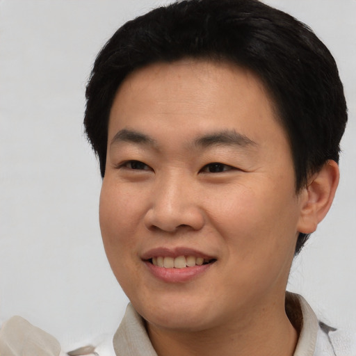 Joyful asian young-adult male with short  black hair and brown eyes