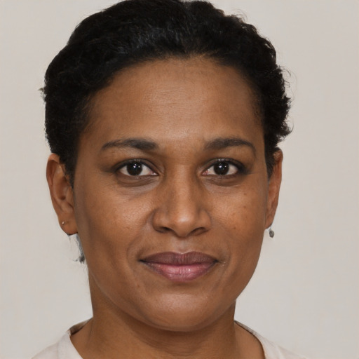 Joyful black young-adult female with short  black hair and brown eyes