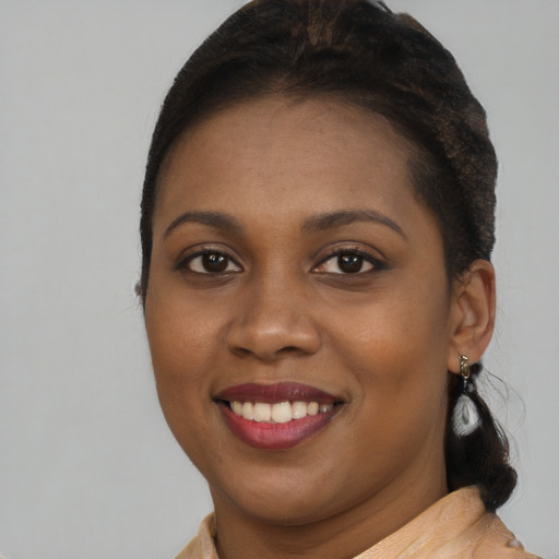 Joyful black young-adult female with long  brown hair and brown eyes
