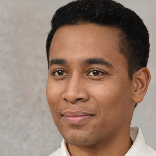 Joyful latino young-adult male with short  black hair and brown eyes