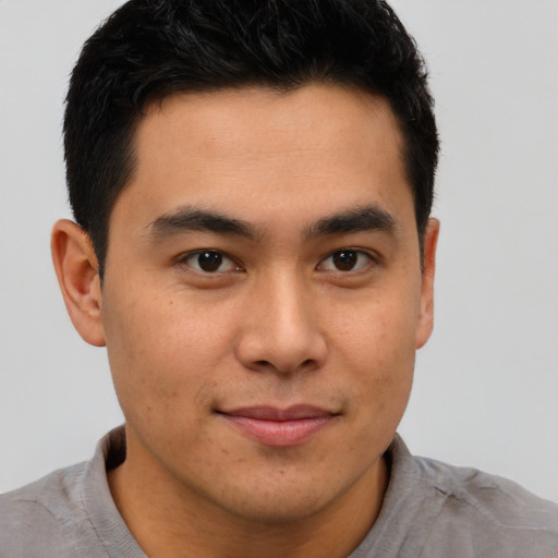 Joyful latino young-adult male with short  brown hair and brown eyes