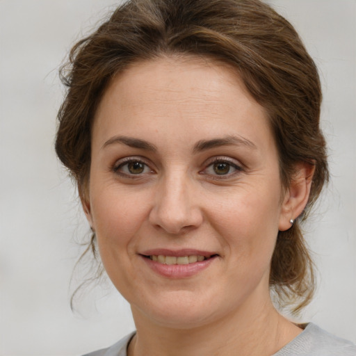 Joyful white young-adult female with medium  brown hair and green eyes