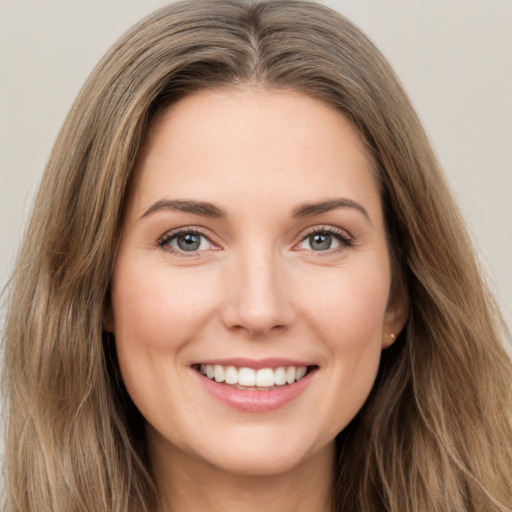 Joyful white young-adult female with long  brown hair and green eyes