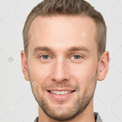 Joyful white young-adult male with short  brown hair and grey eyes