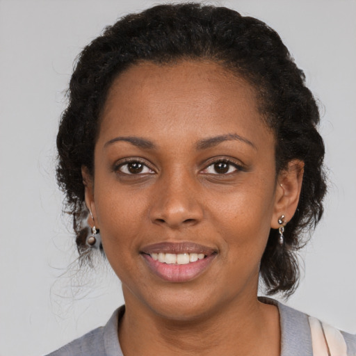 Joyful black adult female with short  brown hair and brown eyes