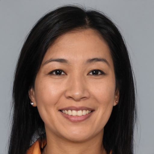 Joyful asian young-adult female with long  brown hair and brown eyes