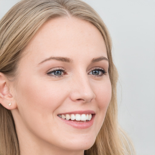 Joyful white young-adult female with long  brown hair and blue eyes